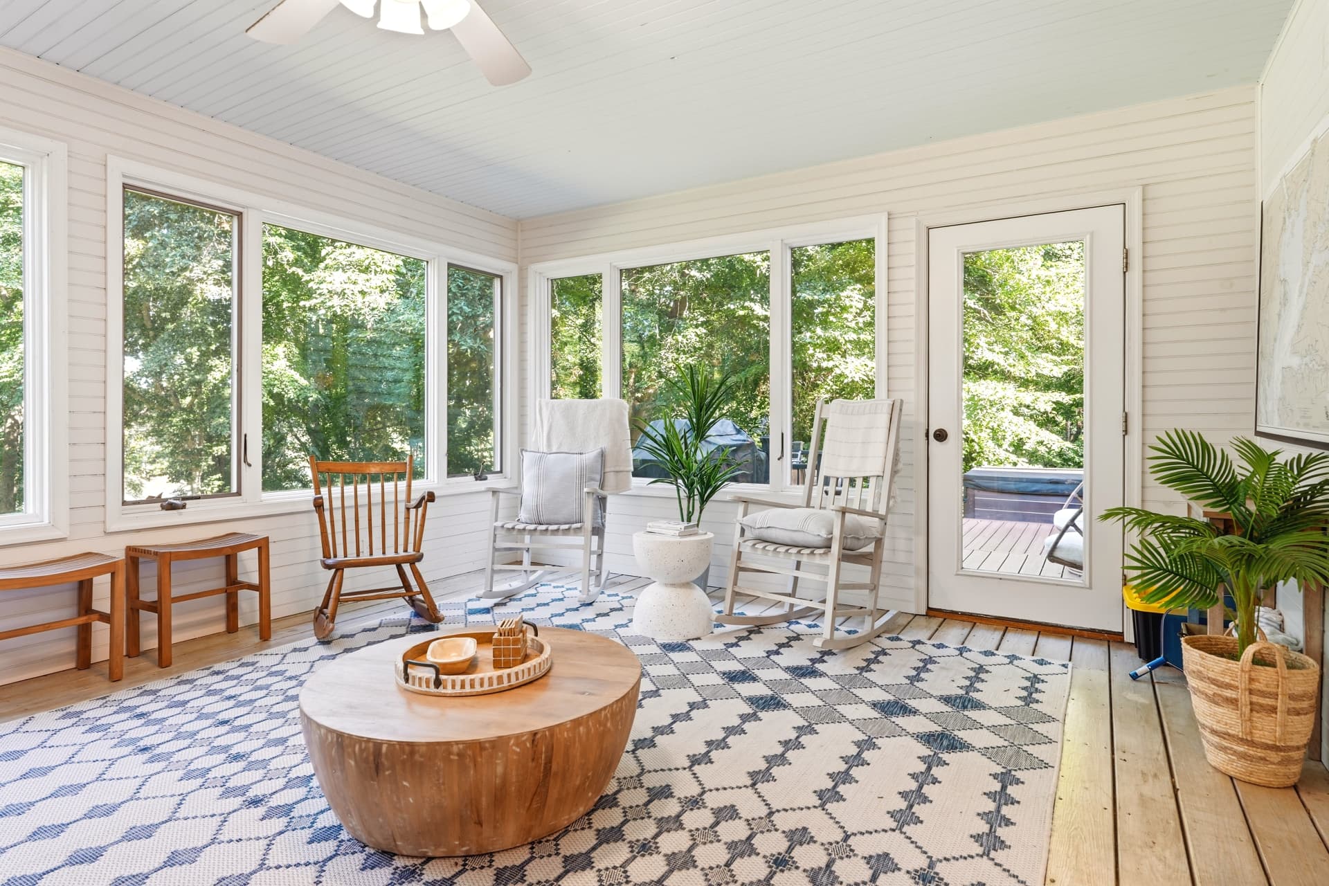 Screened porch with rocking chairs and wooded views