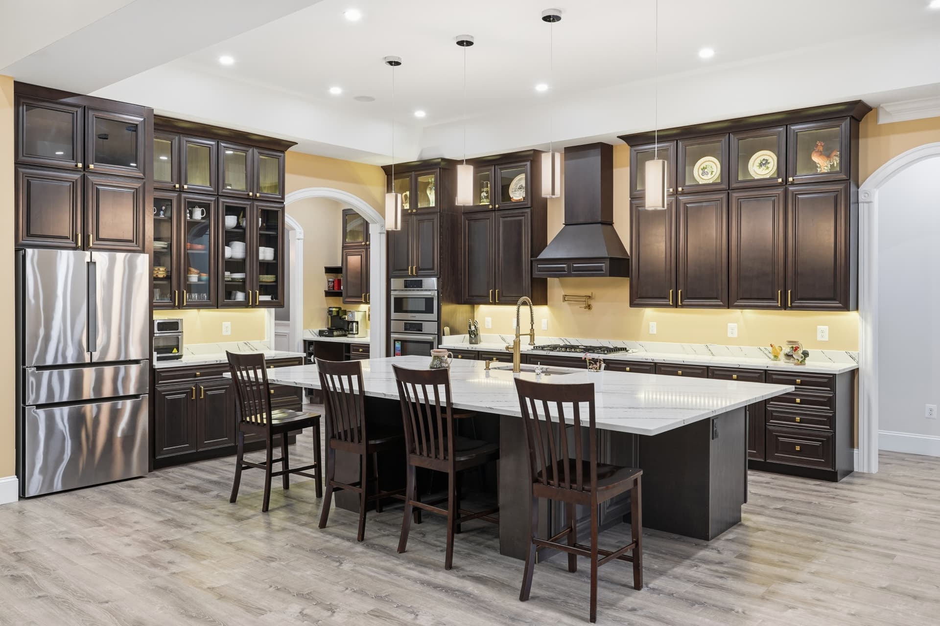 Kitchen with dark espresso cabinetry and marble island seating