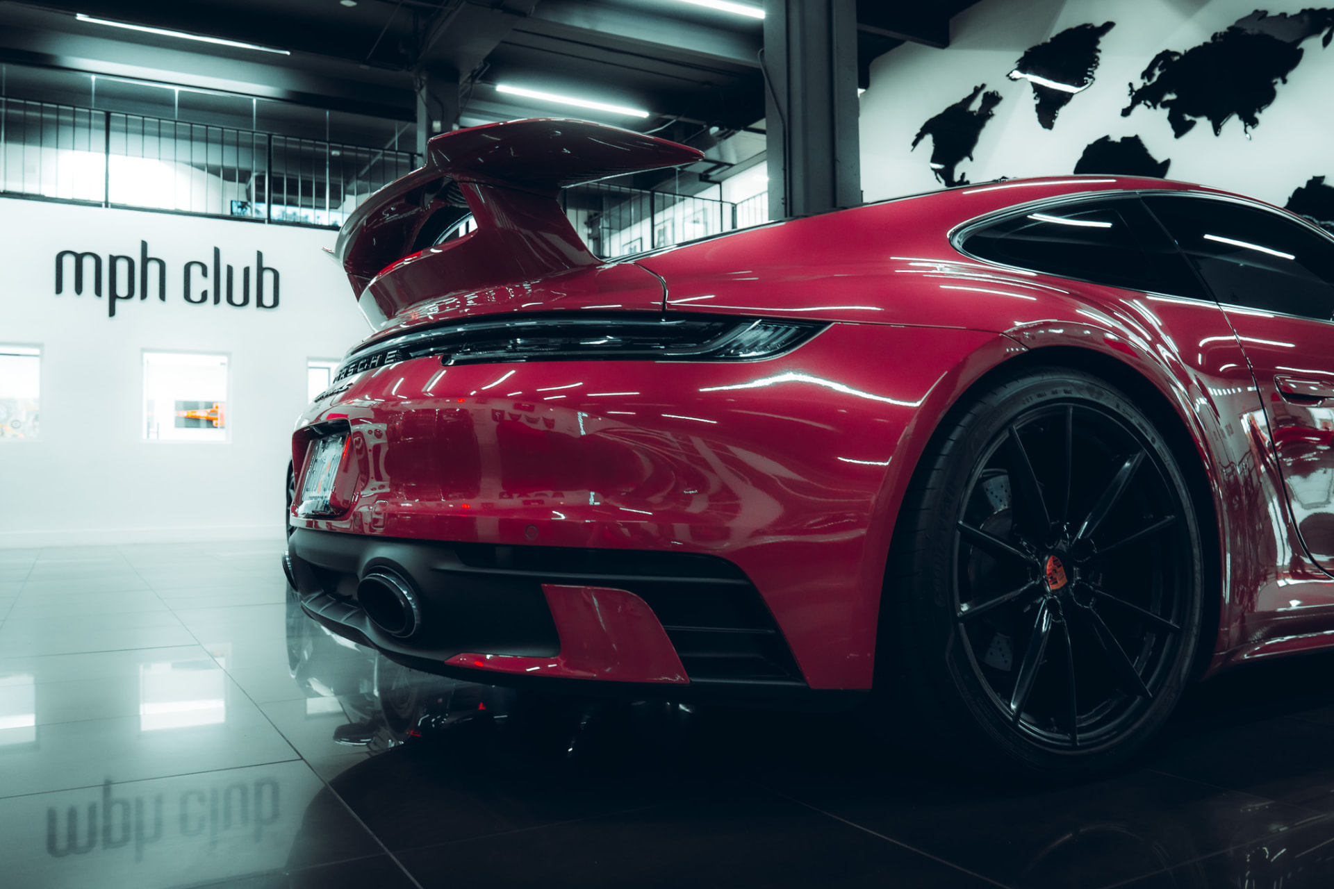 Red Porsche 911 Turbo rear wing inside a showroom