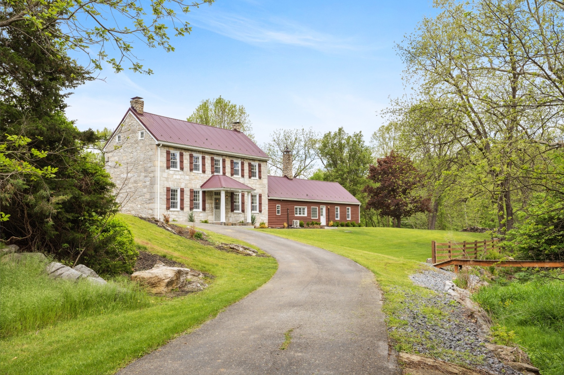 Historic stone farmhouse with red metal roof