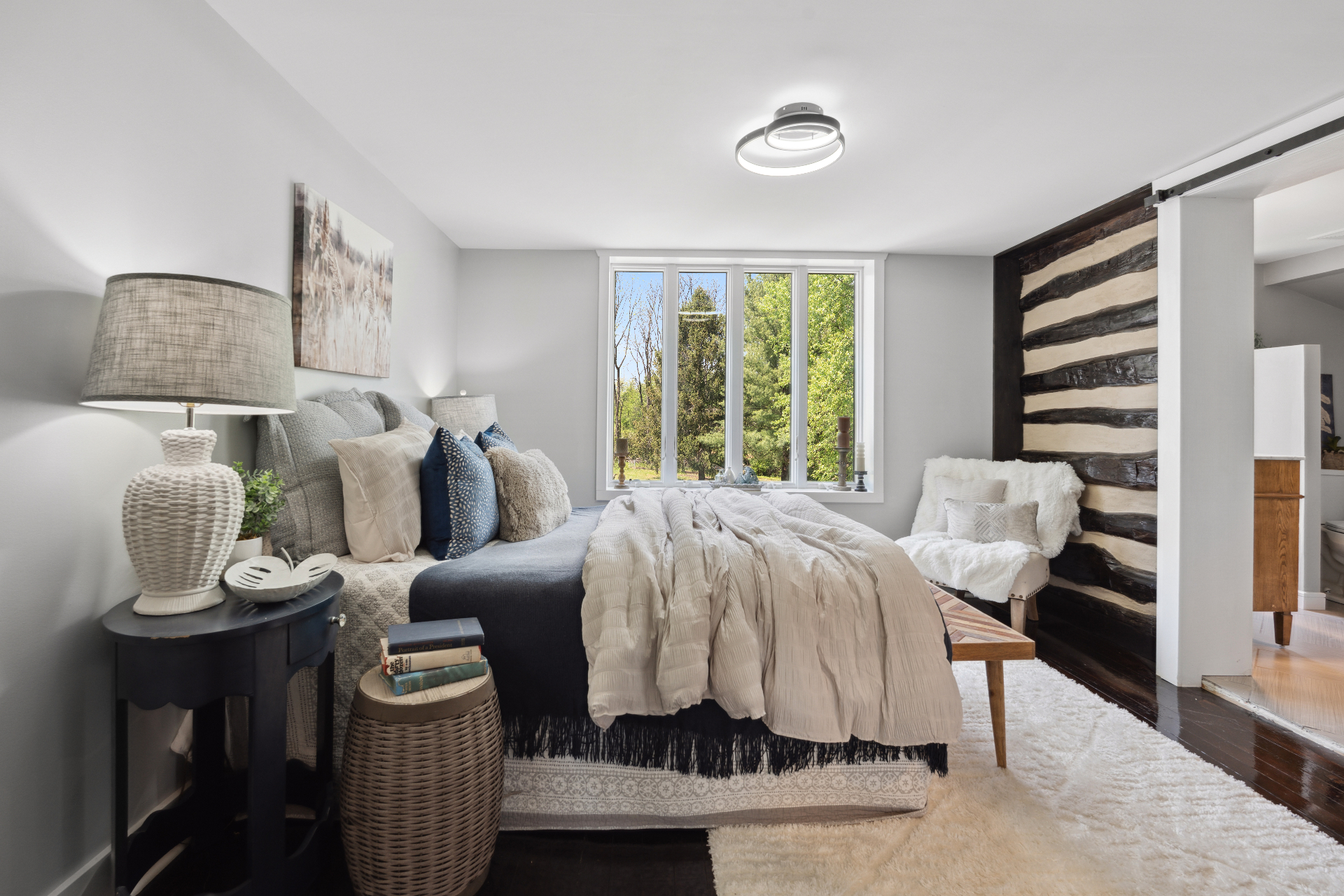 Bedroom with log accent wall and layered neutrals
