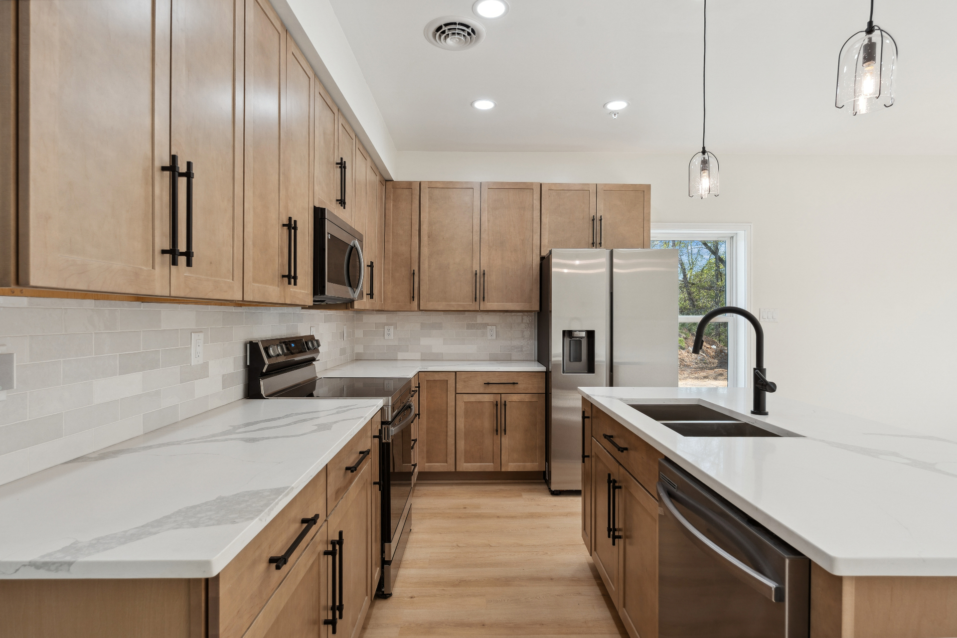 Maple kitchen with quartz counters and pendant lights