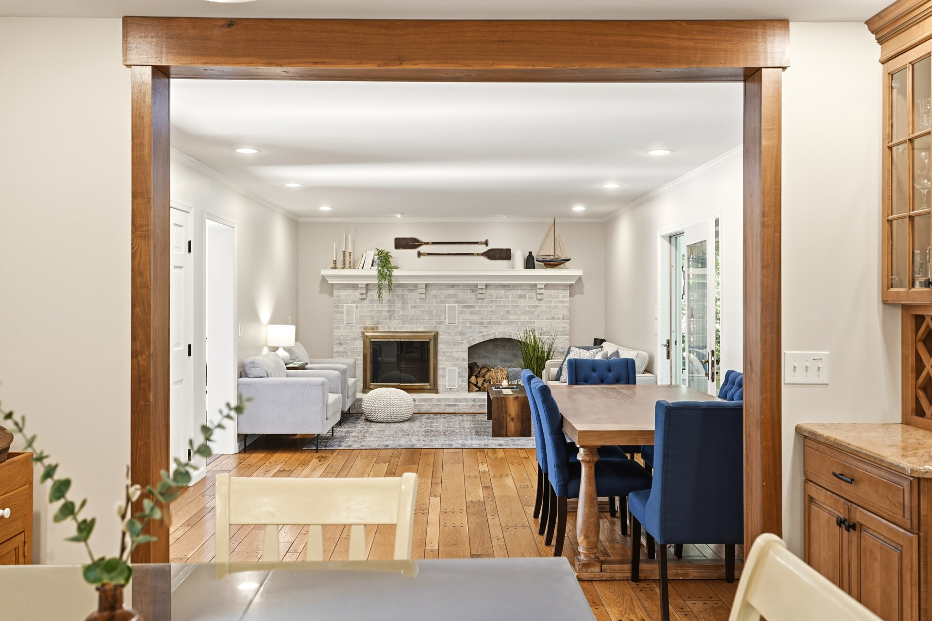 Open dining and living room with brick fireplace and timber beam